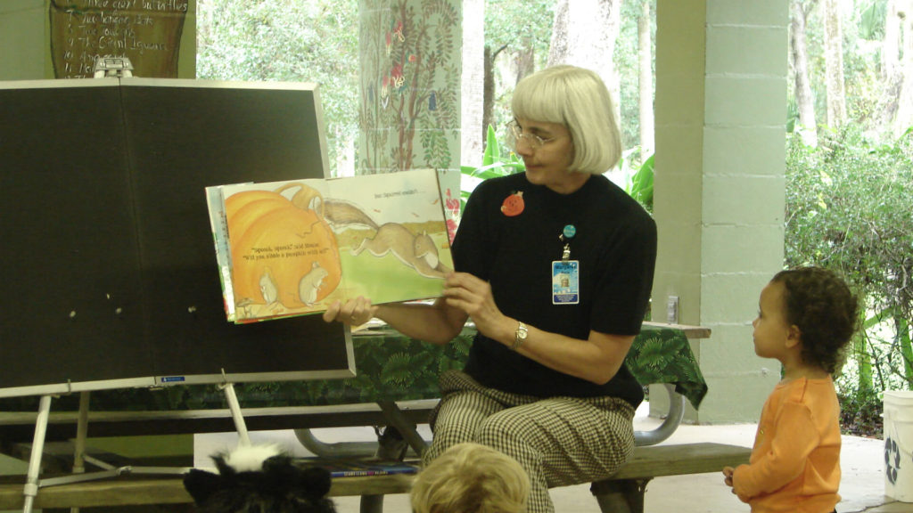 A woman reads to a group of children during Storytime at the Zoo