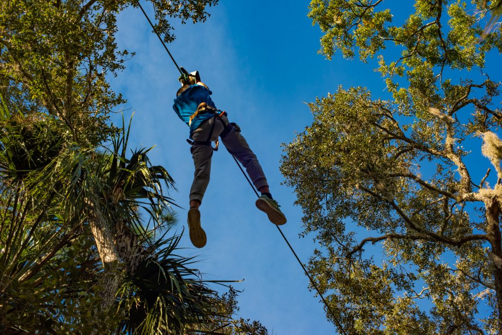 A person in an attraction crossing through a rope