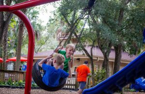 Children enjoying swings at playground amenity at the Central Florida Zoo